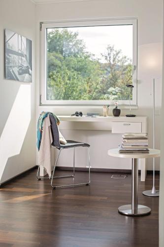 a desk and a chair in a room with a window at THE FLAG Zürich in Zürich