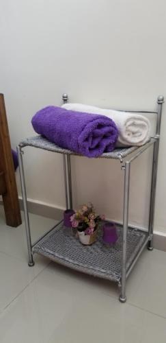 a towel rack with towels and flowers on it at Appartement Confort Fann hock in Dakar