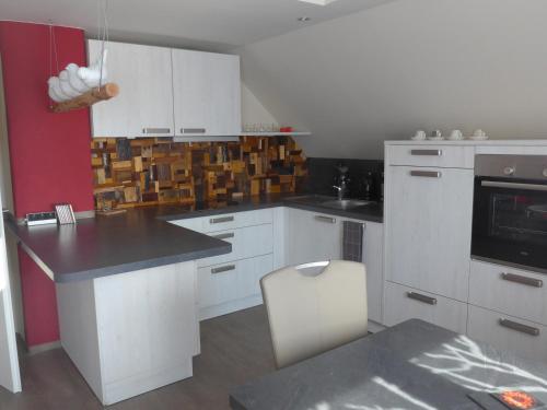 a kitchen with white cabinets and a black counter top at CasaNova in Bad Windsheim