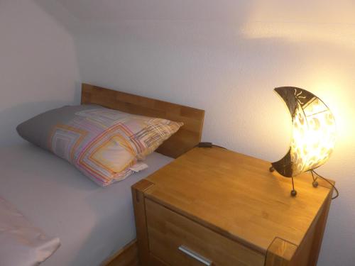a bedroom with a bed and a lamp on a dresser at CasaNova in Bad Windsheim