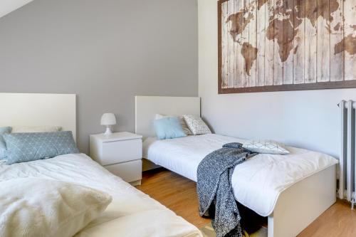 エスブリーにあるFreedomus Marne-La-Vallée "Le Briard"のベッド2台付きの部屋、壁に地図を用意しています。