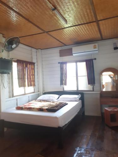 - un lit dans une chambre avec 2 fenêtres dans l'établissement Baan Bar Cafe, à Mae Chaem