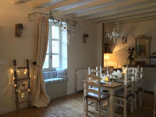 une salle à manger avec une table et des chaises et une fenêtre dans l'établissement La douceur Angevine, à Montreuil-Bellay