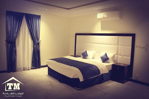 a bedroom with a large bed in a room at شقق الزوايا الهادئه للشقق المخدومة - اقتصادي - Alzwaya Alahadea Apartments in Jeddah