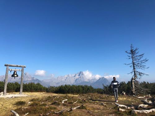 a man standing on top of a hill with a bell at Haus Schlager "dasAppartement" in Annaberg im Lammertal