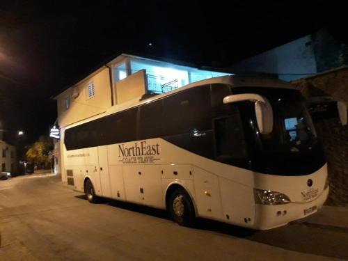 a bus parked in front of a building at night at Villa Zigana in Mostar