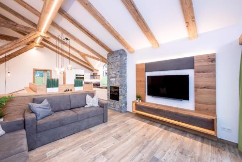 a living room with a couch and a large tv at Gasteg Living in Maria Alm am Steinernen Meer