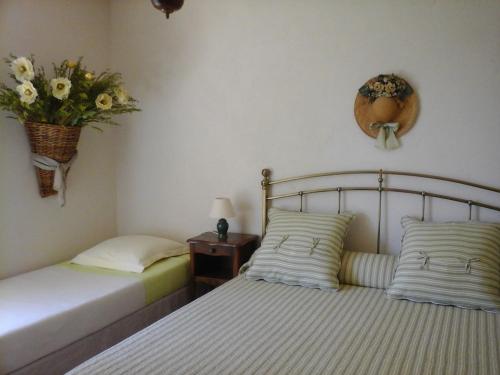a bedroom with two beds and a vase of flowers on the wall at La Maison de Campagne in Carcès