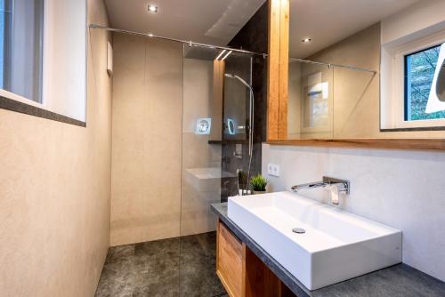 a bathroom with a white sink and a mirror at Gasteg Living in Maria Alm am Steinernen Meer