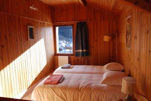 モンジェネヴルにあるgrand chalet plein sudの木製の部屋にベッド1台が備わるベッドルーム1室があります。