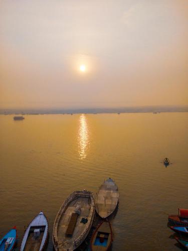 a group of boats in the water at sunset at Dwivedi Hotels Palace On Steps in Varanasi