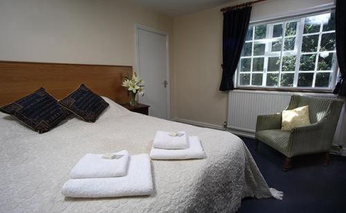 a bedroom with a large bed with towels on it at The Staff Of Life in Ticknall