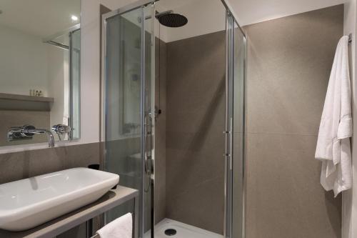 a bathroom with a glass shower and a sink at Brianteo Hotel Residence and Restaurant in Burago di Molgora