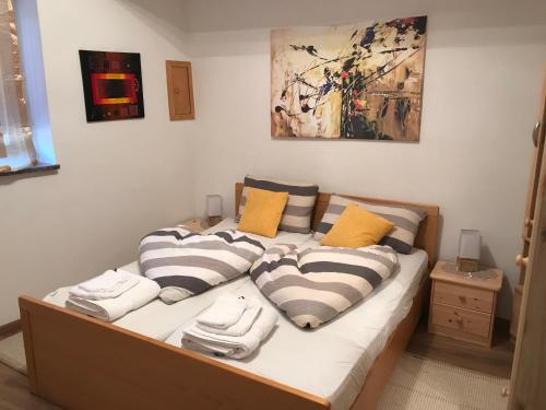 una cama con almohadas y toallas en una habitación en Appartamento Giustina, en Gargazzone