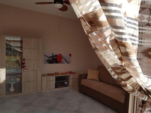 Villa Giada في كامبوفيليتْشّي دي روتْشّيلا: غرفة معيشة مع أريكة ومروحة سقف