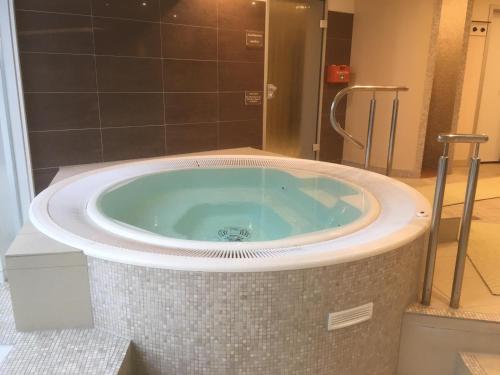 eine große Badewanne im Bad mit Dusche in der Unterkunft Lord Nelson Apartment 13 in Cuxhaven
