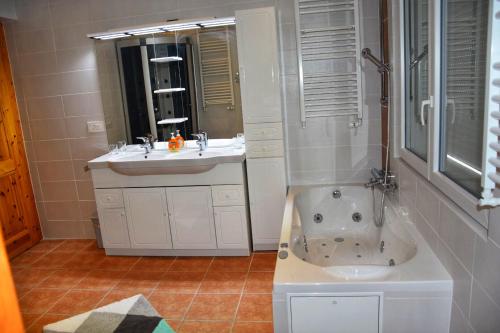 uma casa de banho com uma banheira, um lavatório e um chuveiro em Chalet Belmont em Ovronnaz