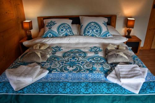 a blue and white bed with towels on it at Chalet Belmont in Ovronnaz