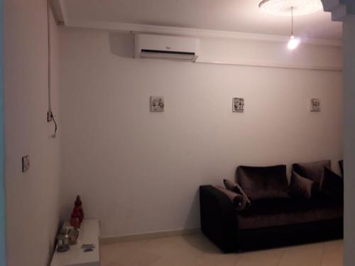 a living room with a black couch in a room at Etablissement moderne in Safi