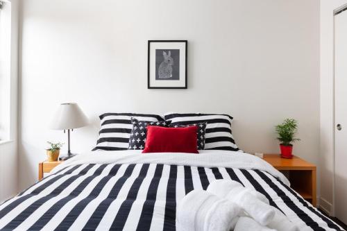a bedroom with a black and white bed with a red pillow at Uptown Gem in Chicago