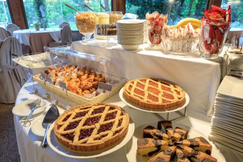 a table with pies and other pastries on it at Brianteo Hotel Residence and Restaurant in Burago di Molgora