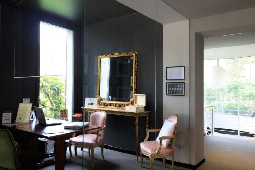a room with a desk with a mirror and chairs at Brianteo Hotel Residence and Restaurant in Burago di Molgora