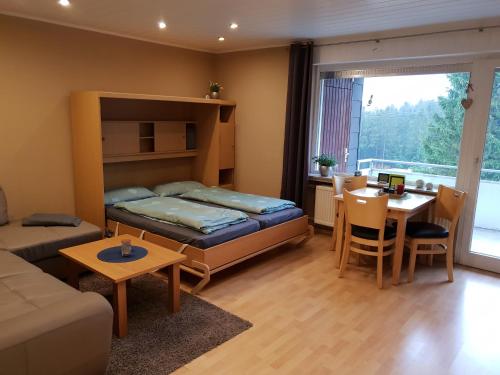 ein Wohnzimmer mit einem Bett und einem Esszimmer in der Unterkunft Ferienwohnung Singer Am Erlebnisbocksberg in Goslar