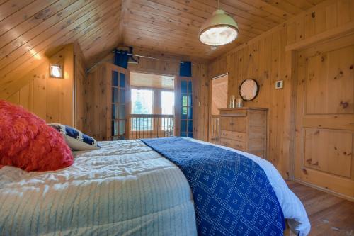a bedroom with a bed in a wooden cabin at Log Cabin Home with Lake and Mountain view by Reserver.ca in Sainte-Adèle