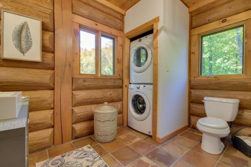 a bathroom with a toilet and a washing machine at Log Cabin Home with Lake and Mountain view by Reserver.ca in Sainte-Adèle