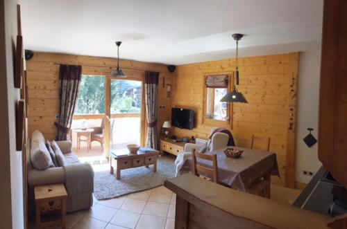 ein Wohnzimmer mit einem Sofa und einem Tisch in der Unterkunft ECRINS ETOILE C9 in Samoëns