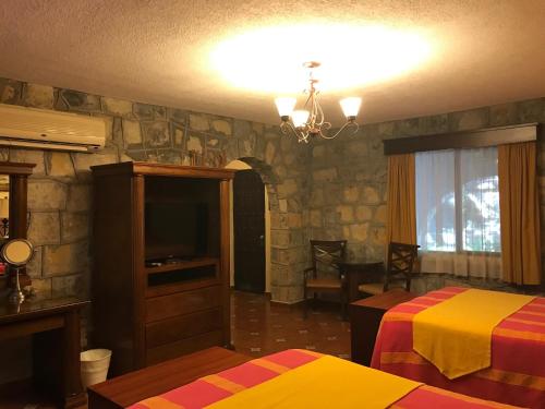 a hotel room with two beds and a television at Hotel Valles in Ciudad Valles