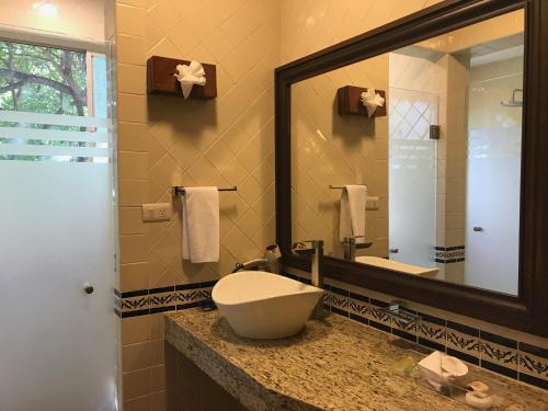 a bathroom with a sink and a large mirror at Hotel Valles in Ciudad Valles