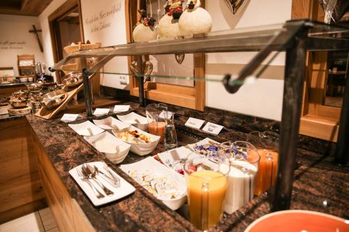 a buffet line with plates of food and candles at Hotel Friedenseiche in Benediktbeuern