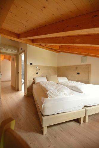a large bed in a room with a wooden ceiling at Ai Vellutai in Ala