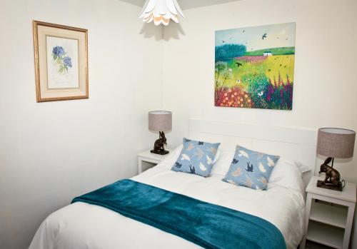 a bedroom with a bed and a painting on the wall at Lowerbourne House Studio in Porlock