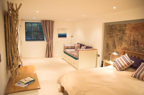 1 dormitorio con 2 camas y ventana en No1 The Pottery, Dartmouth, en Dartmouth