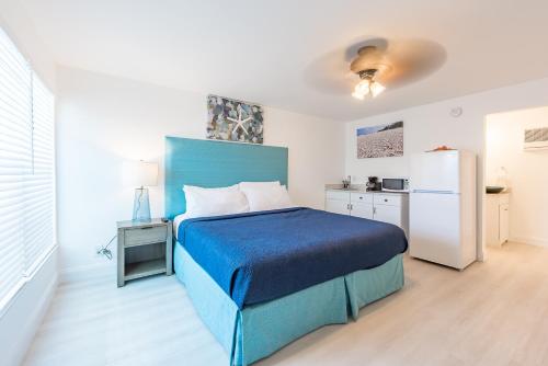 a bedroom with a blue bed and a refrigerator at Sea Beach Plaza in Fort Lauderdale