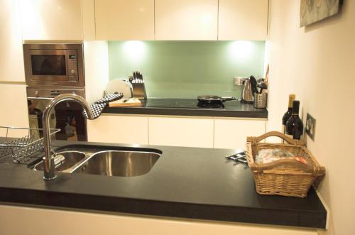 a kitchen counter with a sink and a microwave at No1 The Pottery, Dartmouth in Dartmouth