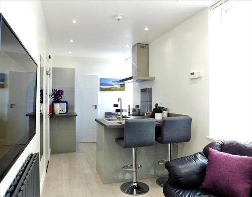 a kitchen with two chairs and a bar in a room at Studio 5 in Woolacombe