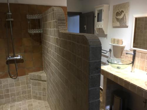a bathroom with a stone shower and a sink at Mas de charme Les Pellegrins in Saintes-Maries-de-la-Mer