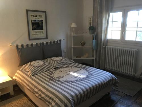 ein Schlafzimmer mit einem Bett mit einer gestreiften Decke in der Unterkunft Mas de charme Les Pellegrins in Saintes-Maries-de-la-Mer