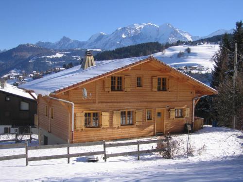 a log cabin in the snow with mountains at Chalet Le Sabot De Venus in Combloux