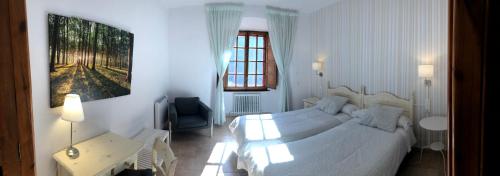 a bedroom with a bed and a desk and a window at MONASTERIO de SANTA MARÍA DE VALVANERA in Anguiano
