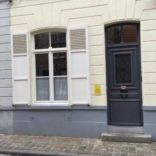 a house with a black door and two windows at Kruitenberg in Bruges