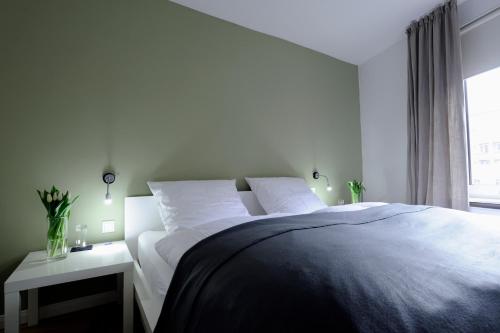 a white bed with two pillows next to a window at Hotel KUHBERG Hamburg in Hamburg