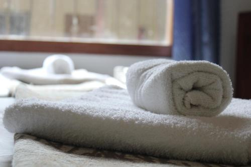 a pile of towels sitting on top of a bed at Palo Rosa Lodge in Puerto Iguazú