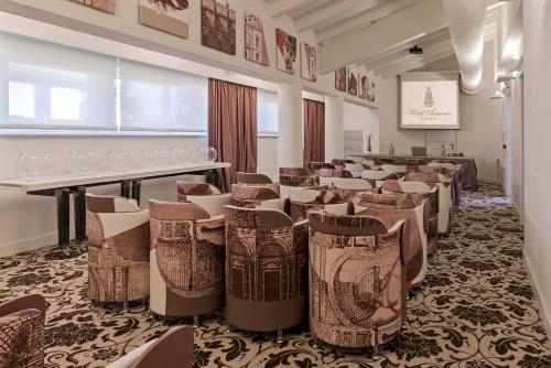 a room with a bunch of chairs and tables at Hotel Armonia in Pontedera