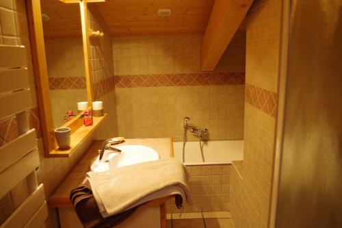 La salle de bains est pourvue d'un lavabo et d'une baignoire. dans l'établissement Chalet Le Sabot De Venus, à Combloux