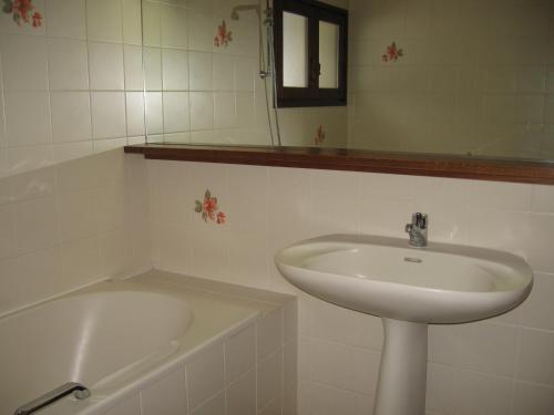 een witte badkamer met een wastafel en een bad bij Grangettes in Les Carroz d'Araches