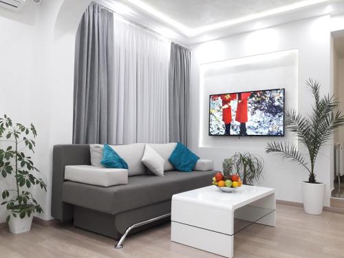 ein Wohnzimmer mit Sofa und Tisch in der Unterkunft Apartmani Abbazia in Banja Luka